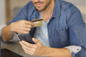 Obraz na płótnie Canvas man making online purchase on his smartphone
