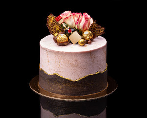 Delicious chocolate cake for the holiday with a bottle and chocolates.