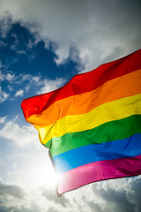Close-up of gay pride rainbow flag fluttering backlit in bright sunny sky