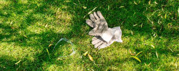 working in garden, protective gloves and glases laying on green grass