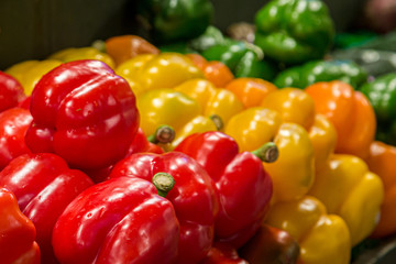 A variety of colourful bell peppers for sale on a market stall