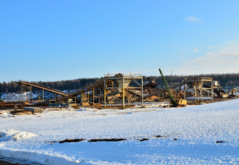 Sand mining in winter conditions in an industrial quarry. Conveyor Belt in mining quarry, Mining industry. Amazing mountains against the backdrop of snow and industry