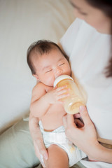 Newborn baby girl is drinking milk by  her mother