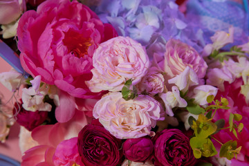 Colorful mixed bouquet with various spring flowers in floral decor, Colorful wedding flowers background . Mixed flower arrangement: various flowers in different shades of red, pink, yellow and orange.