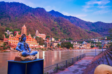 Idol of Indian God Shiva, at the bank of river Ganga in Rishikesh with blurred temple in background , the yoga  capital of India. Indian Tourism  