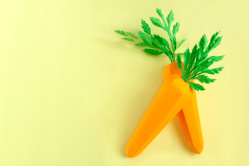 Two paper carrots on yellow background