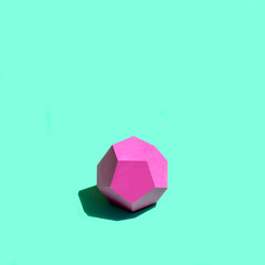 Paper pink dodecahedron in bright sunshine