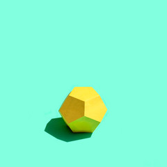 Paper yellow dodecahedron in bright sunshine
