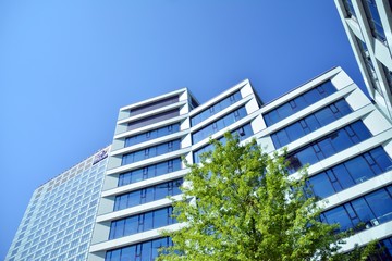 New office building in business center. Wall made of steel and glass with blue sky. 