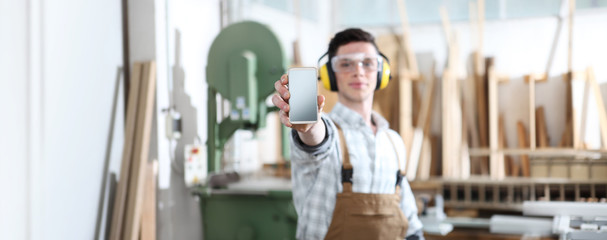 carpenter man show the mobile phone isolated on carpentry background