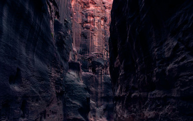 photography inside of canyon in twilight pink and red lighting from sunset between steep rock walls, USA natural scenic landscape path way object 