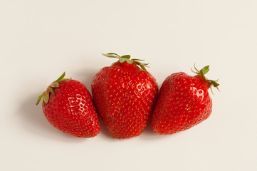 Three fresh red strawberries on white background