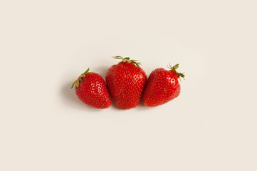 Three fresh red strawberries on white background