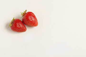 Two fresh red strawberries on white background