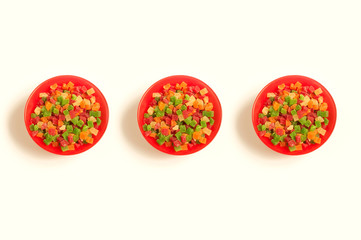 Red round plate full of colorful delicious candied fruits