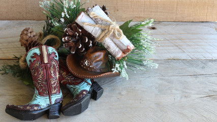 teal and red cowboy boots and hat next to pine with a bundle of tied wood  laying on a wood...