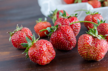 succulent juicy fresh ripe red strawberries on a dark wooden table