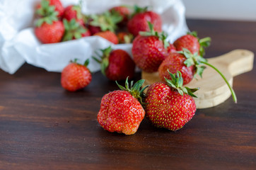 succulent juicy fresh ripe red strawberries on a dark wooden table
