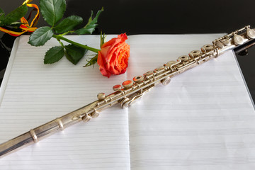 Cross flute silver-plated on empty musical score © Leonardo Macedo