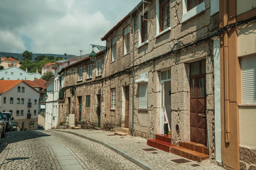 Fototapeta na wymiar Old houses with stone wall in a deserted alley