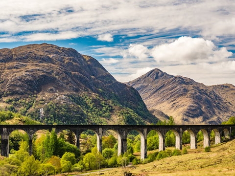 Glenfinnan Viaduct And Historical Train In Scotland