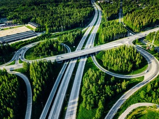 Obraz na płótnie Canvas Aerial view of highway and overpass with green woods in Finland.
