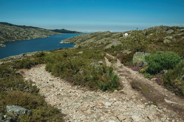 Fototapeta na wymiar Trail over rocky terrain and lake on highlands