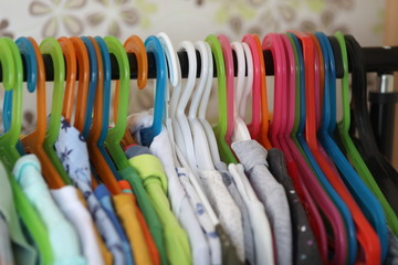 a lot of colourful hangers with bright clothes