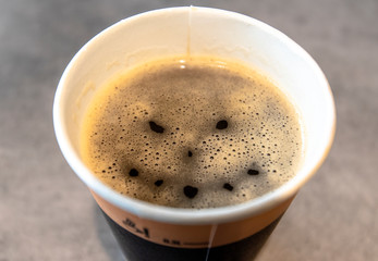 Angry Face on Surface of Coffee in paper Cup - conceptual Picture Coffee as Drug