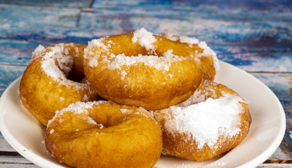 Fresh donuts with powdered sugar on the table