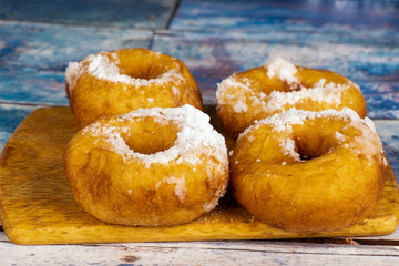 Fresh donuts with powdered sugar on the table