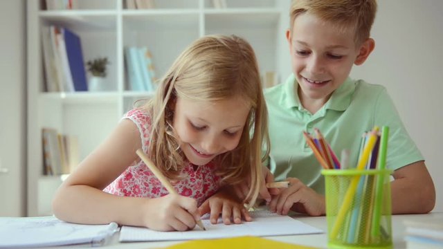 Cute schoolchildren doing homework together