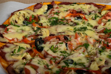Hunting pizza with sausage, beef, tomatoes and olives