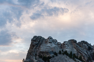 A dramatically colorful sky developing around sunset behind the four US presidents of Mount Rushmore, in North Dakota.