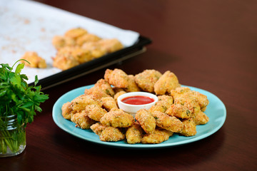 Fried crispy chicken nuggets with ketchup on the plate