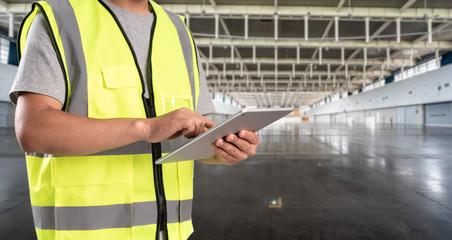 worker hand holding pad for check order pick time in empty warehouse