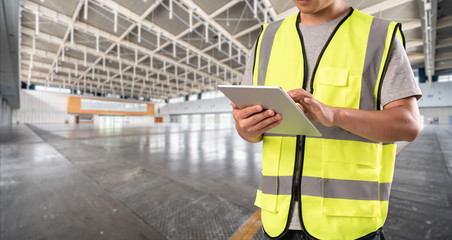 worker hand holding pad for check order pick time in empty warehouse