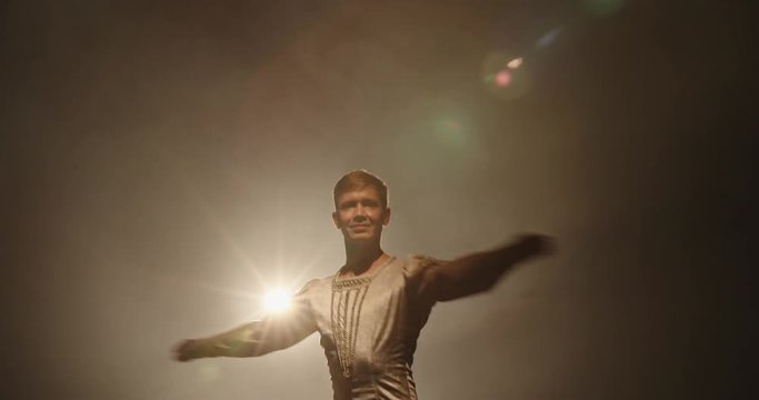 Handsome Caucasian Male Ballet Dancer Performing Pirouette And Spinning On Stage, Wearing White Tights, Spotted By Searchlight And Isolated On Black Background 4k Footage
