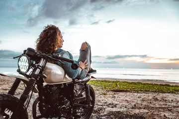 Papier Peint photo Moto Belle fille s& 39 amusant à conduire sa moto de course de café personnalisée, profitant du coucher de soleil sur la plage