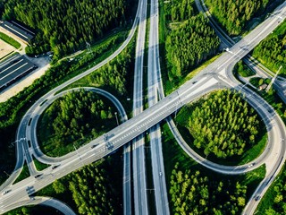 Aerial view of highway and overpass with green woods in Finland.