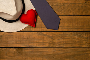 Set of elegant male accessories, men's fashion. Tie, panama hat and fabric heart on rustic wooden background. The concept of father's day card, copy space for text.