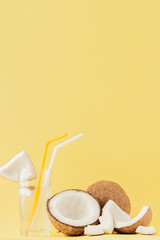 Fototapeta na wymiar Fresh Coconut cocktail with a straws on yellow background, copy space