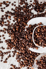 Black coffee in white cup and coffee beans on light wooden background. Top view, space for text