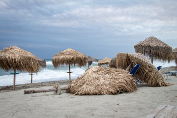Beschädigte Sonnenschirme nach Sturm an einem Strand