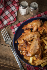 Baked chicken wings with french fries.