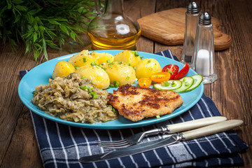 Fried pork chop, baked potatoes and fried young cabbage.