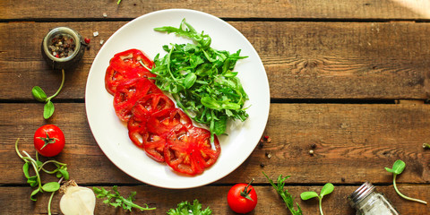 salad with tomatoes, arugula, balsamic sauce (fresh vegetables and salad dressing). Top view. copy space