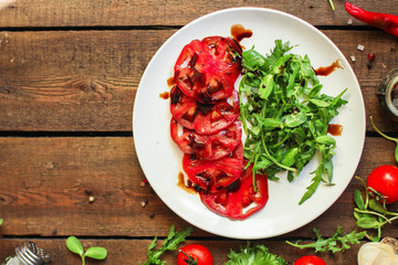 salad with tomatoes, arugula, balsamic sauce (fresh vegetables and salad dressing). Top view. copy space