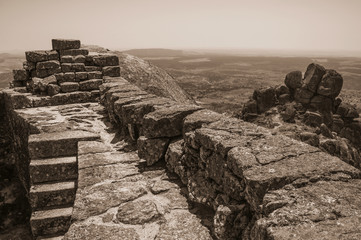Stone wall on hilltop covered by rocks at the Castle of Monsanto