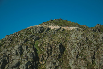 Retaining wall of road passing through rocky landscape